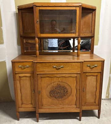 une vieille armoire en bois surmontée d'un miroir