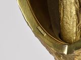 a gold statue of a woman holding a banana in her hand