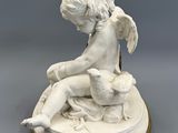 an image of a statue of a child sitting on top of a table