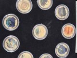 a black box with twelve different colored coins in it