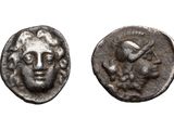 a close up of a coin with a face on it