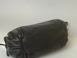 black leather toiletry bag sitting on a white surface with a white background