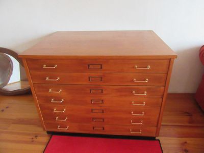 une commode en bois dans une pièce avec un tapis rouge