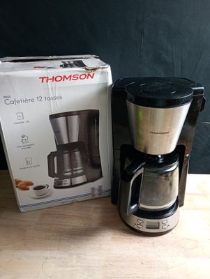 une cafetière posée à côté d'une boîte sur une table