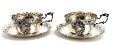 pair of silver plated tea cups and saucers on a saucer
