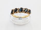 an image of a gold ring with black and white stones on it