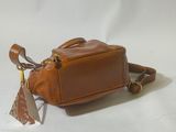 brown leather handbag on white background with a tag attached to it
