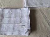 two towels that are on a bed with a name on them