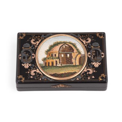 une boîte noire et dorée sur laquelle est représentée une maison