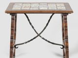 an image of a small table with a tile top and iron legs