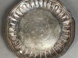 a silver plate on a table that has a design on it