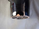 a close up of a black coffee mug on a white cloth