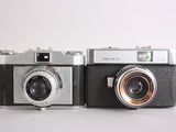 two old cameras sitting side by side on a table