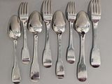 six fourchettes et six cuillères sur une table