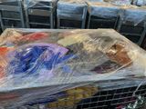 a cart full of items wrapped in plastic on the ground
