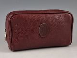 a brown leather toilet bag on a white surface