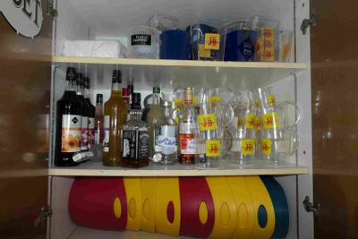 many bottles and glasses on the shelves in the cabinet