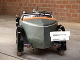 a small green car with a sign attached to it