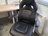 une chaise de bureau noire assise devant un bureau d'ordinateur