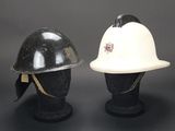 two helmets are sitting on top of each other on a black surface