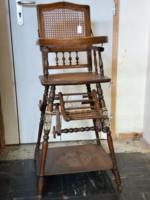a wooden high chair that is sitting in the corner of a room