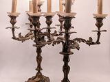 an image of a chandelier with five candles and a bird on it