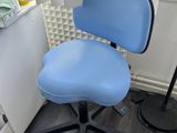 a blue office chair sitting in front of a window