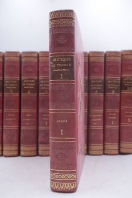 many old books lined up on a shelf in a row