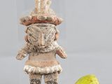 une figurine représentant un homme debout à côté d'une poire