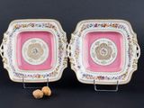 une paire d'assiettes roses et dorées ornées de motifs floraux