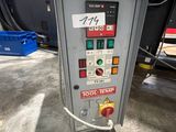 un gros plan d'une machine dans un entrepôt, sur laquelle est accrochée une pancarte