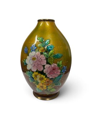un vase orné de fleurs peintes, posé sur une surface blanche