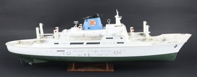 une maquette de bateau posée sur un socle, sur fond noir
