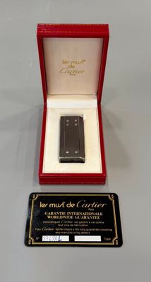 un téléphone portable noir dans une boîte rouge posée sur une table