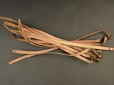 several leather straps on a gray surface with one strap tied to the other