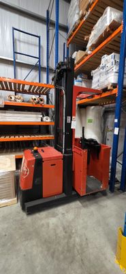un chariot élévateur dans un entrepôt rempli de cartons et de palettes