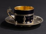 a cup and saucer sitting on a black table