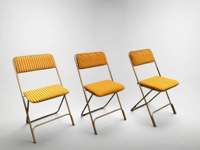 three yellow folding chairs against a white background