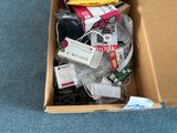 une boîte en carton remplie d'appareils électroniques posée par terre