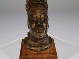 a wooden sculpture of a woman ' s head on a wooden base
