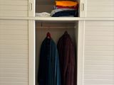 an image of a closet with clothes hanging on it