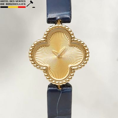 a gold watch with a blue strap on a white background