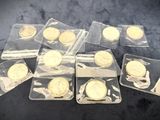 several gold coins are in plastic bags on a black surface