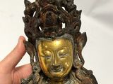 an image of a person holding a statue of a buddha