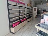 many shelves in the store that have pink boxes on them