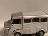un petit bus en plastique posé sur une surface blanche