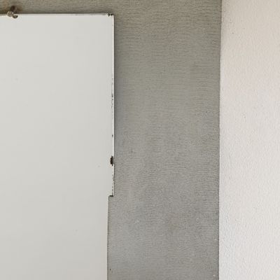 une porte blanche dans un coin d'une pièce, près d'un mur