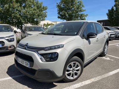 une Citrole blanche garée sur un parking aux côtés d'autres voitures