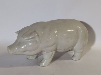 figurine en porcelaine représentant un cochon sur fond blanc