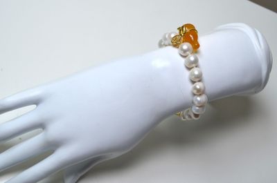 Un bracelet en perles de culture avec une breloque